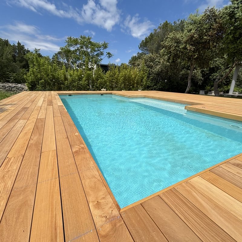 Terrasse en bois exotique posée autour d'une piscine enterrée dans le Gard, réalisée par Articréa