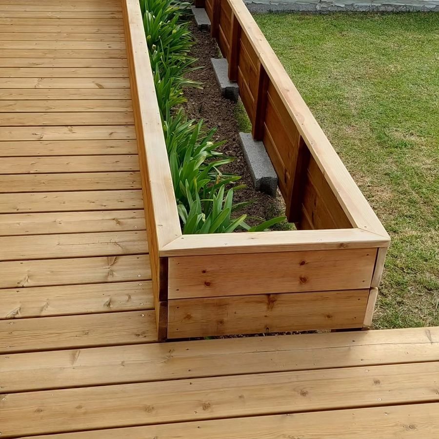 Jardinière en bois intégrée à une terrasse, plantée d'agapanthes