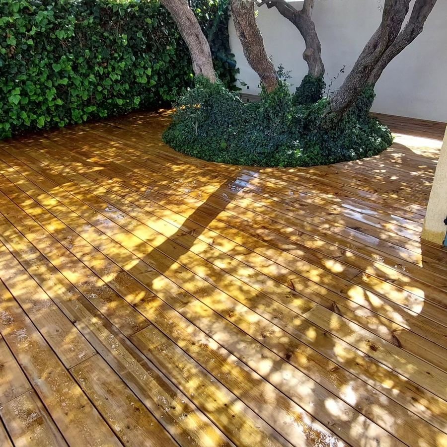 Terrasse en bois massif construite autour d'un olivier